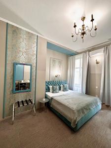 Schlafzimmer mit einem Bett mit einem Spiegel und einem Kronleuchter in der Unterkunft Family Residence Boutique Hotel in Lwiw