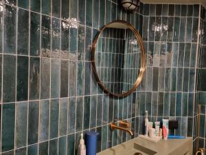 baño con espejo en la pared de azulejos en Sunny Terrace in Modern Flat with AC, en París