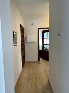 un pasillo vacío con suelo de madera y puerta en Apartamento Portonovo centro, en Portonovo