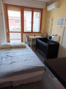 a bedroom with a bed and a desk and a window at Casa di Gabriella in Grado