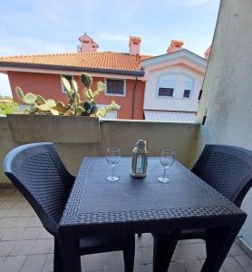 a table with two wine glasses on a balcony at Casa di Gabriella in Grado