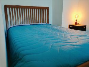 a large blue bed with a wooden headboard and a table at Casa Relax Diano Castello in Diano Castello