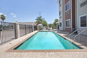 a swimming pool in front of a building at Microtel Inn & Suites by Wyndham Houston/Webster/Nasa/Clearlake in Nassau Bay