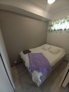 ロヴァニエミにあるHaapalaのベッドルーム1室(紫の毛布が敷かれたベッド1台付)
