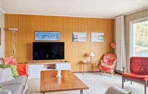 ein Wohnzimmer mit einem Sofa und einem TV in der Unterkunft Nice Home In Lyngdal With House Sea View in Lyngdal