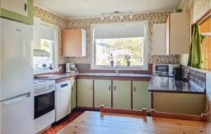eine Küche mit einem Waschbecken und einem Fenster in der Unterkunft Nice Home In Lyngdal With House Sea View in Lyngdal