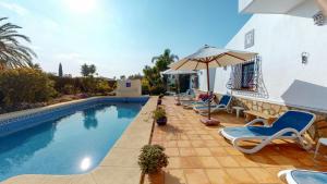 - une piscine avec des chaises et un parasol dans l'établissement Villa Limonero by Family Homes, à Jávea