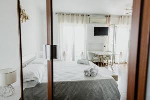 een witte slaapkamer met een bed en een spiegel bij 90 UpMurat Top Floor - City Center & Seaview in Bari
