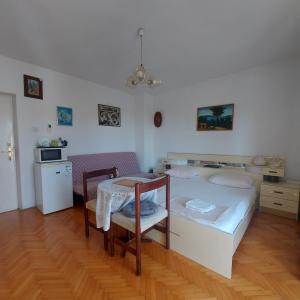 ein Schlafzimmer mit einem Bett und einem Tisch sowie eine Küche in der Unterkunft The best location in Makarska, free bikes in Makarska