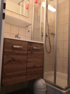 een badkamer met een douche en een houten kast bij Appartementhaus Martel - Adults Only in Travemünde
