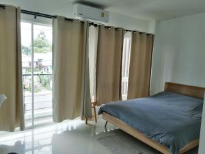 a bedroom with a bed and a large window at Baan7984 Rawai in Rawai Beach