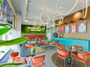 a fast food restaurant with tables and chairs at IBIS Styles Kaunas Centre in Kaunas