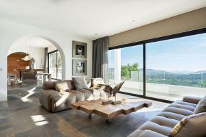 een woonkamer met een bank en een tafel bij Villa Larosa with seaview in Es Cubells Ibiza in Es Cubells
