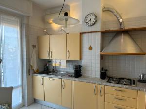 a kitchen with yellow cabinets and a clock on the wall at CA TEA in Lavagna