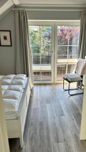 a bedroom with a bed and two large windows at Friesenhof in Friedrichskoog