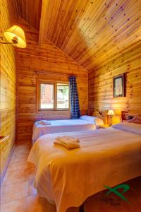 a bedroom with two beds in a wooden cabin at Xixerella Park Bungalows in Xixerella