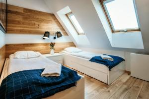 2 camas en un dormitorio en el ático con tragaluces en VisitZakopane - Superior Apartment, en Zakopane