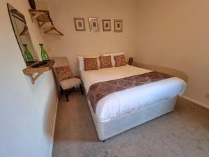 a small bedroom with a bed and a chair at The Globe Inn in Penrith