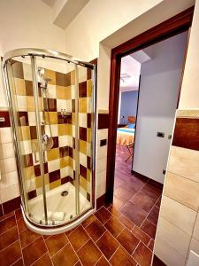 a bathroom with a shower and a tiled floor at B&B L'Angolino della nonna in Castelluzzo