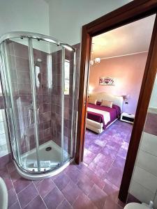 a bathroom with a shower and a bedroom at B&B L'Angolino della nonna in Castelluzzo