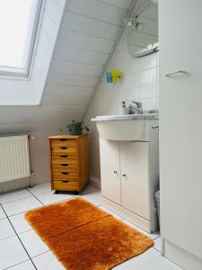 ein Bad im Dachgeschoss mit einem Waschbecken und einem Spiegel in der Unterkunft GLÜCKSHAUS Ferienwohnung in Cuxhaven