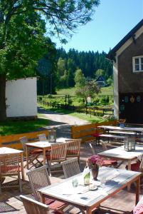 a group of tables and chairs in a patio at Waldgasthaus & Pension Teichhaus in Holzhau