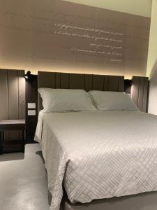 a bedroom with a large white bed with writing on the wall at Donna Caterina in Monopoli