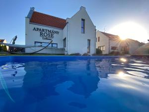 a house with a swimming pool in front of a building at Apartmány ROSE Lednice in Lednice