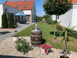 un jardín con una estatua de un perro en un barril en Apartmány ROSE Lednice, en Lednice