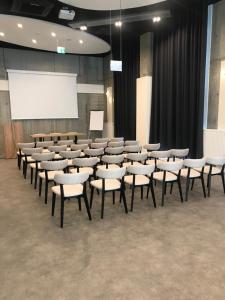 sala wykładowa z krzesłami i białym ekranem w obiekcie Campanile Krakow South w Krakowie