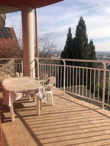 a porch with a table and chairs on a balcony at Panoráma apartman in Pécs