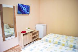 ein kleines Zimmer mit einem Bett und einem Spiegel in der Unterkunft Стаи за гости Люляк 21 in Pavel Banya