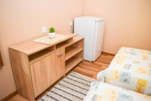 a small room with a refrigerator and a desk at Стаи за гости Люляк 21 in Pavel Banya