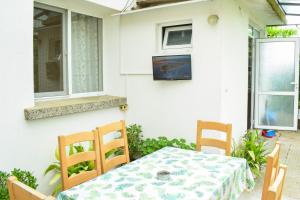 einen Tisch und Stühle auf einer Terrasse mit einem TV in der Unterkunft Стаи за гости Люляк 21 in Pavel Banya