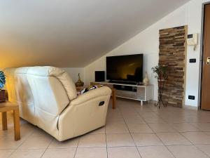un soggiorno con sedia bianca e TV di Mavericklodge a L'Aquila
