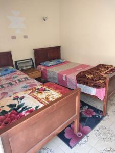 a bedroom with three beds and two tables at Abu Salem Garden- كرم ابو سالم in Saint Catherine