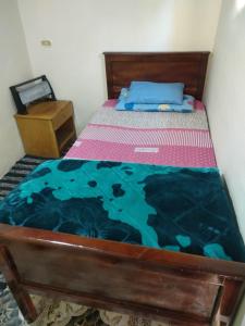 聖凱瑟琳的住宿－Abu Salem Garden- كرم ابو سالم，一间卧室配有一张带蓝色棉被的木床