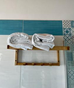 zwei Handtücher auf einem Holzregal im Badezimmer in der Unterkunft Dimora Schiappone in Ischia