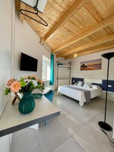 ein Schlafzimmer mit einem Bett und einer Vase aus Blumen auf einem Tisch in der Unterkunft Dimora Schiappone in Ischia