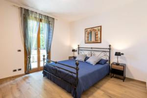 a bedroom with a blue bed and a window at Apartment with garden and parking in Bellagio