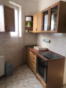 a kitchen with wooden cabinets and a stove top oven at Panoráma apartman in Pécs