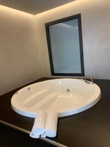 a bath tub in a bathroom with a large mirror at Donna Caterina in Monopoli