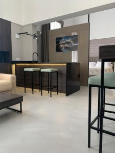 a living room with three bar stools and a bed at Donna Caterina in Monopoli