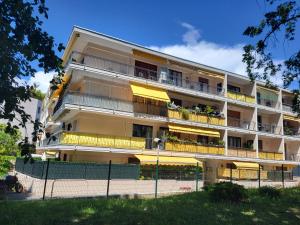 an apartment building with yellow balconies and a fence at Cosy Studio à Cannes 8 min de la Croisette in Cannes
