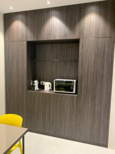 a kitchen with a microwave on a wooden wall at Donna Caterina in Monopoli
