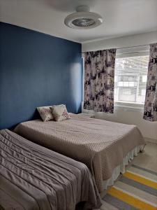 a bedroom with a bed with blue walls and a window at Kempele city center in Kempele