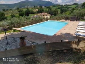 una gran piscina en un patio con mesa y sillas en Azienda Agrituristica Il Moraiolo, en Foligno