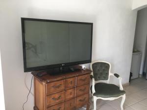 un televisor sentado en la parte superior de un tocador con una silla en Villa Elysae, en Mougins