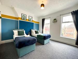 1 Schlafzimmer mit 2 Betten und einem Fenster in der Unterkunft Air Host and Stay - Phillimore - sleeps 9, mins from city free parking in Liverpool
