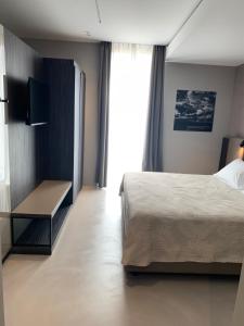 a hotel room with a bed and a television at Donna Caterina in Monopoli